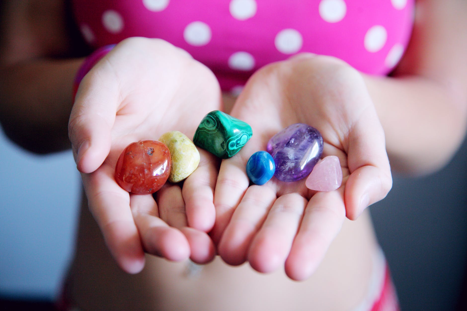 woman holding six polished stones